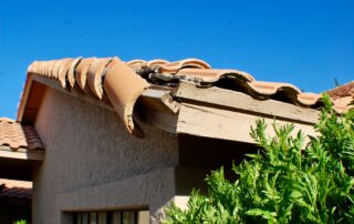 Broken roof tile and exposed wood fascia on residential home showing warning signs of roof replacement, damage from weather and wear in Florida, Castaways Roofing