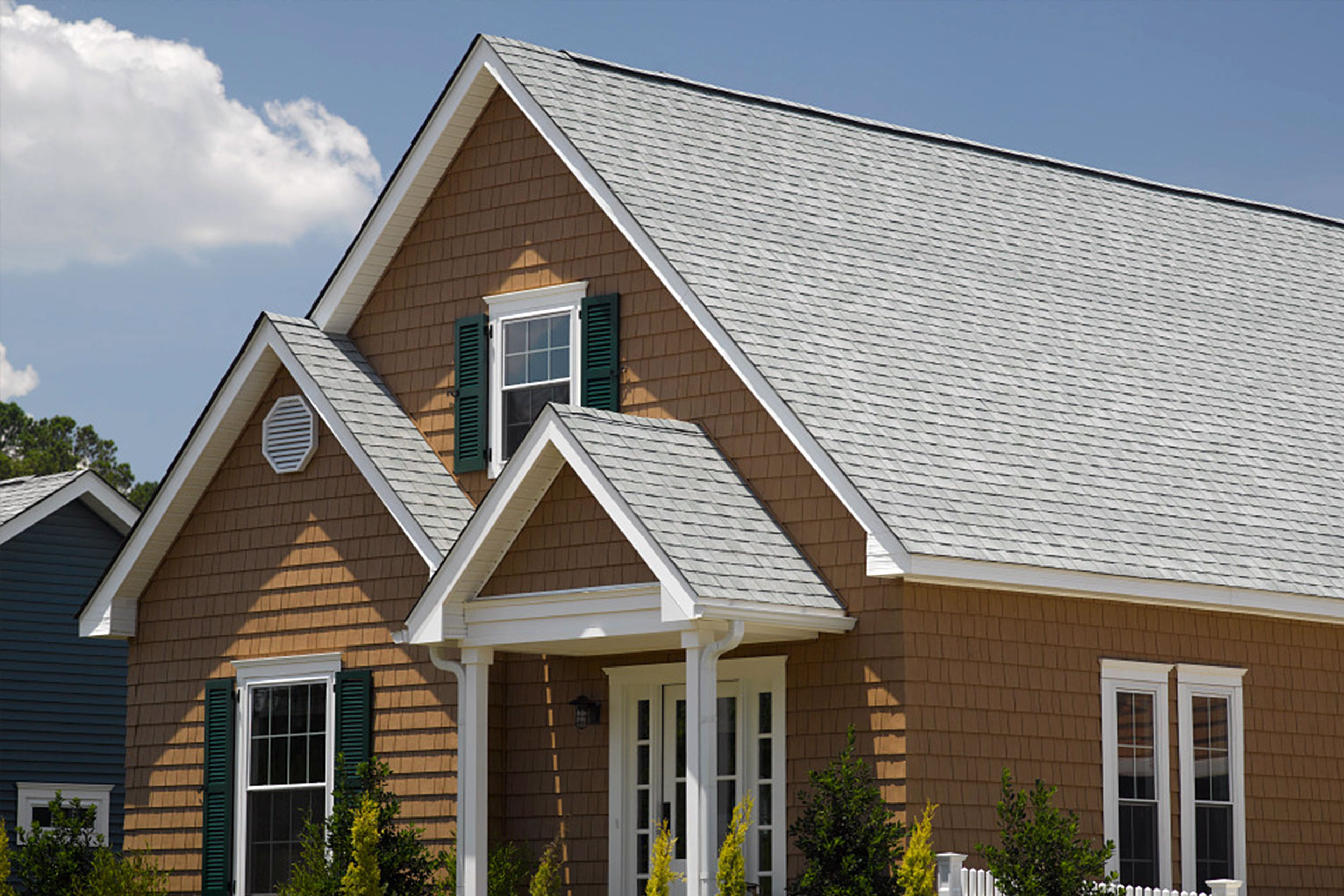 Residential home with architectural shingle roof and steep gabled design, showcasing durable asphalt roofing installation for long-lasting weather protection by Castaways Roofing
