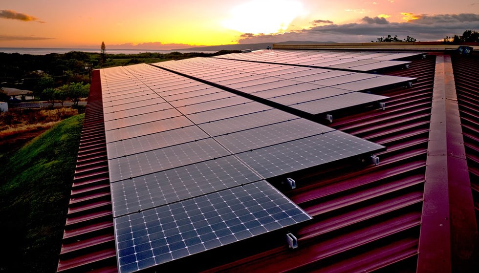 Residential rooftop solar panel installation on metal roof at sunset showing solar roofing integration and renewable energy system by Castaways Roofing Solar panels installed on a metal roof at sunset, maximizing renewable energy production | Castaways Energy